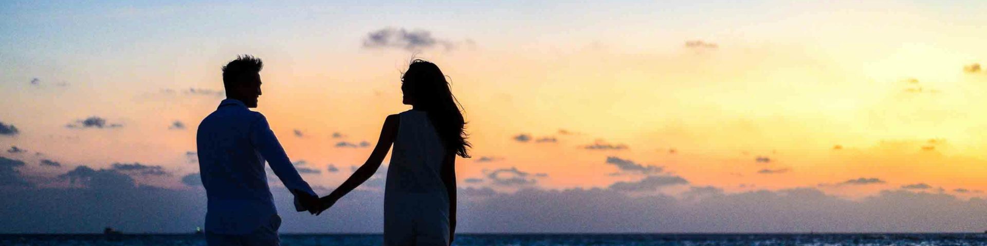 man en vrouw op het strand bij ondergaande zon als afbeelding bij een blog over voortzetting partnerpensioen