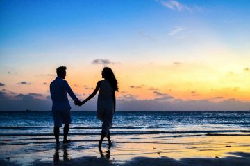 man en vrouw op het strand bij ondergaande zon als afbeelding bij een blog over voortzetting partnerpensioen