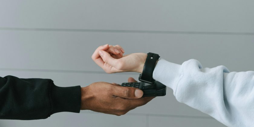 betaal met horloge op mobiel pinapparaat als afbeelding bij een blog over vakantiedagen in pensioen storten