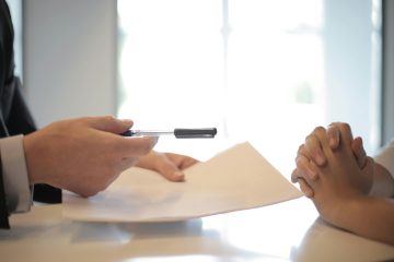 man met pen en verzekeringsvoorwaarden als illustratie bij een blog over pensioen discussie