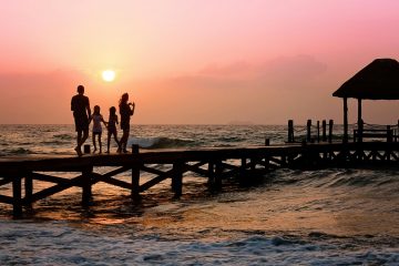 gezin op een pier in zee bij ondergaande zon als illustratie bij een blog over als je overlijdt, vervalt je pensioenpot