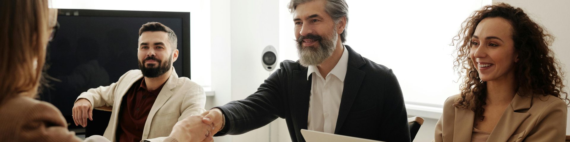 4 mensen aan een bureau bij een sollicitatiegesprek als afbeelding bij een blog over pensioencompensatie bij wisseling van baan